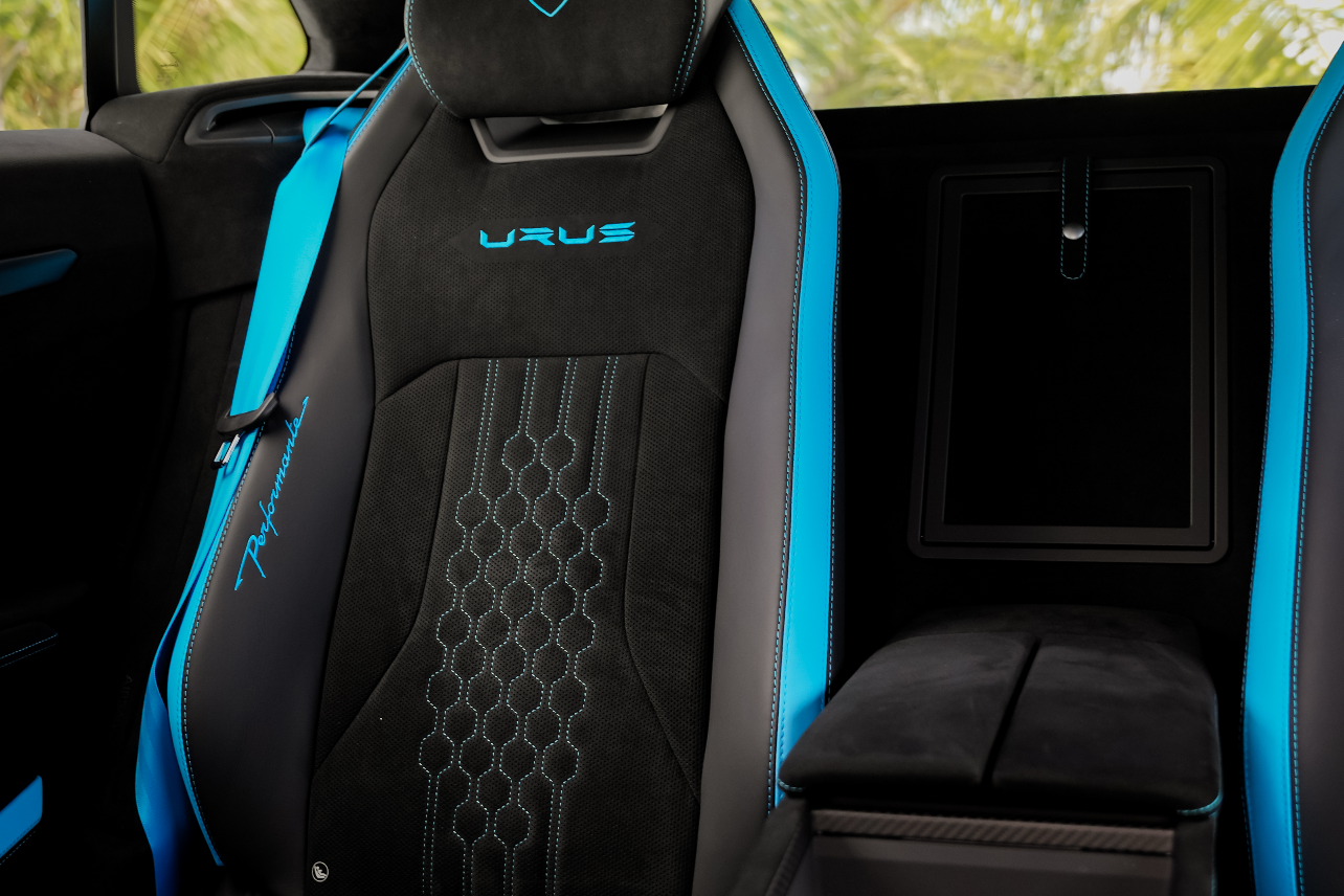 Luxury car interior with black and blue seats featuring a logo.