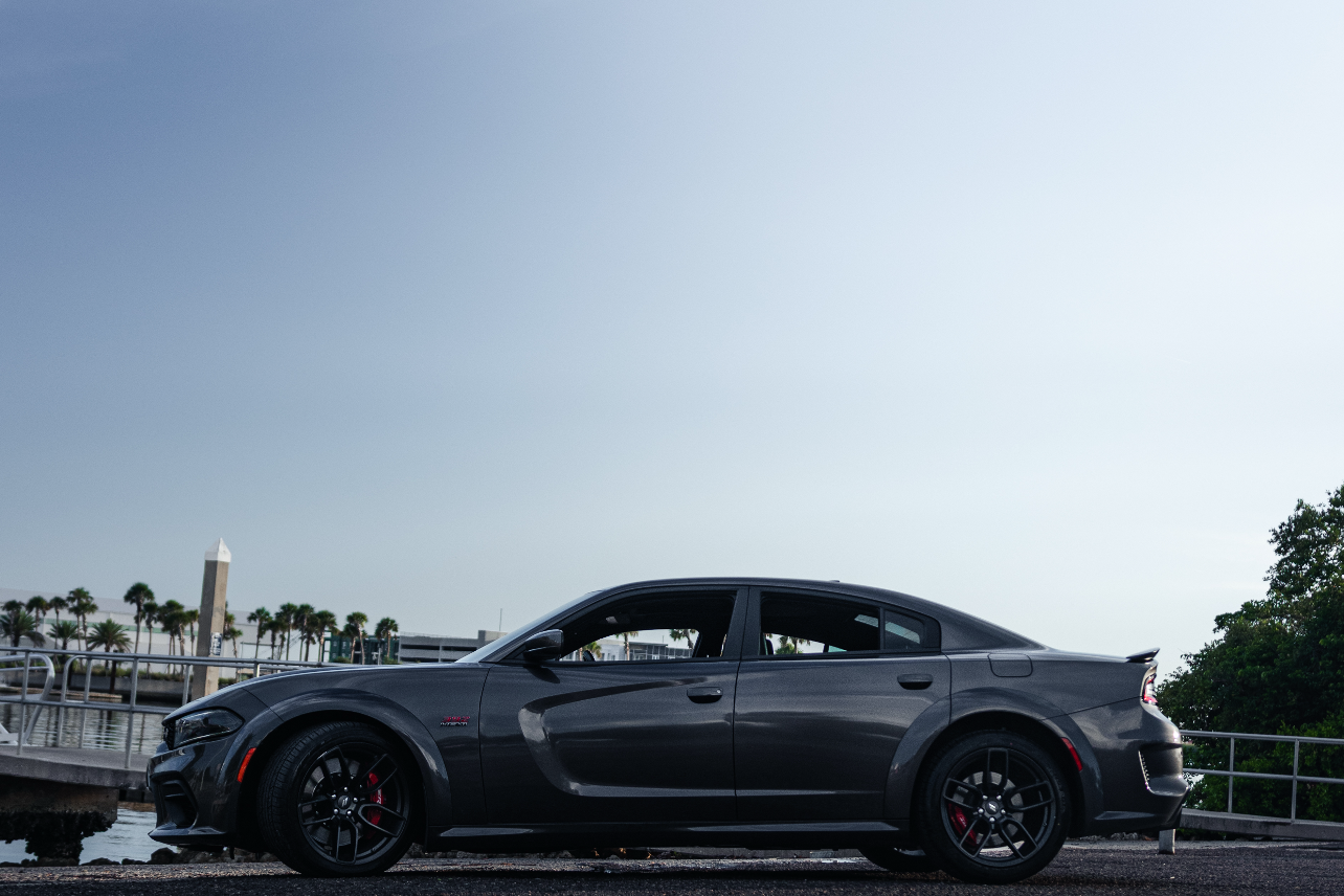 Gray sports car on a road with a clear sky