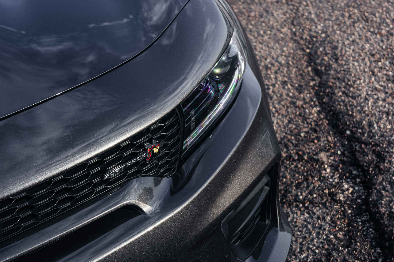 Close-up of a car's front grille on a road surface