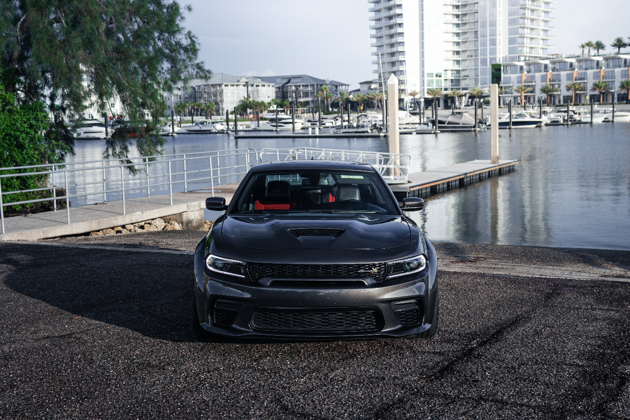 Car parked by a waterfront with buildings in the background
