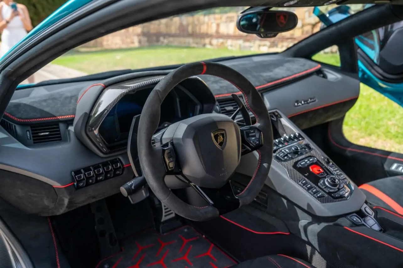 Car interior with steering wheel and dashboard, featuring a prominent brand logo.