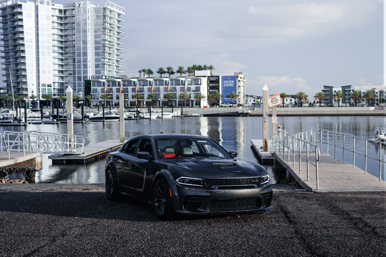 Car parked by a waterfront with buildings in the background